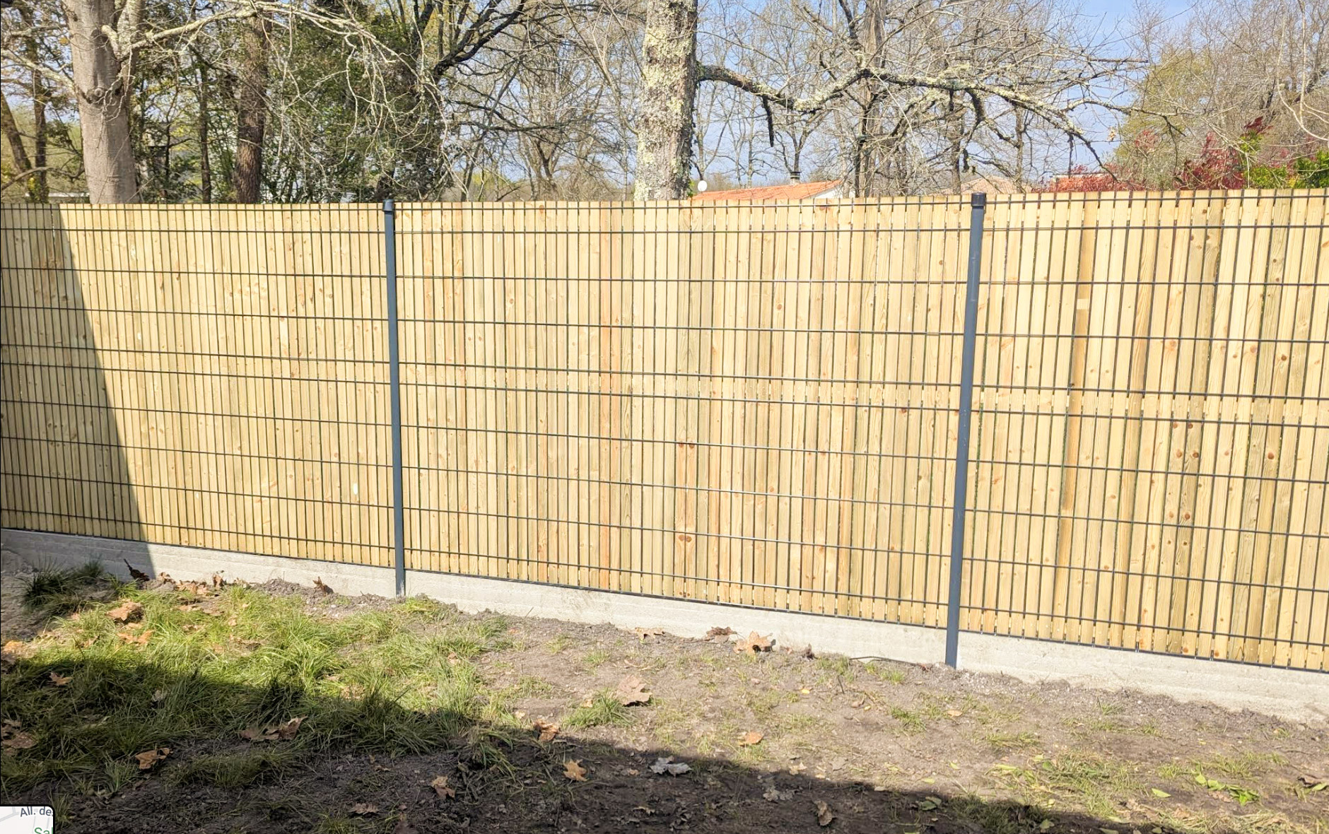 Clôture en panneaux rigides avec lames bois et poteaux anthracite sur soubassement béton, réalisée par TO l'Atelier des Jardins, paysagiste à Bordeaux – aménagement jardin sur-mesure