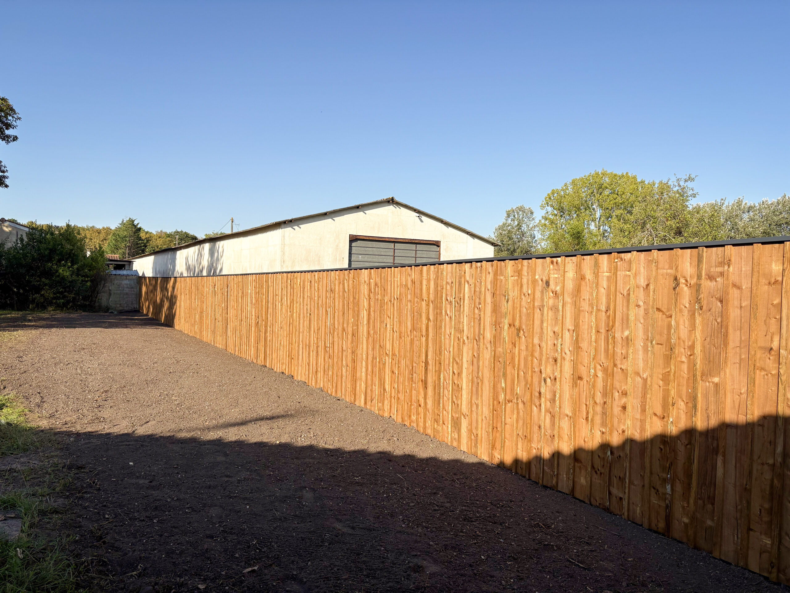 Clôture volige couvre-joint pin maritime avec couvertine anthracite, vue en angle, Le Taillan-Médoc – réalisation TO l'Atelier des Jardins, paysagiste à Bordeaux